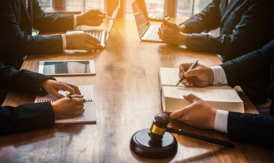Business people at a table with a gavel, discussing and making decisions