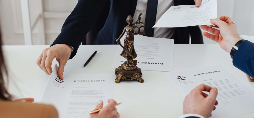 A group of people discussing company law at a table, surrounded by papers and documents