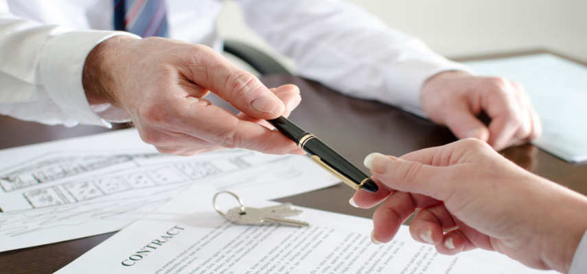 A man holds a pen and a woman holds a key, symbolizing the signing of deeds and agreements
