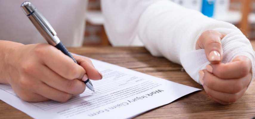 A person with a bandaged hand writing on a paper, possibly related to workers' compensation law